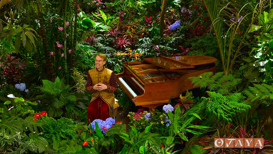 Sukaishi David teaches meditation mantras with piano in the Earthborn Rainforest.