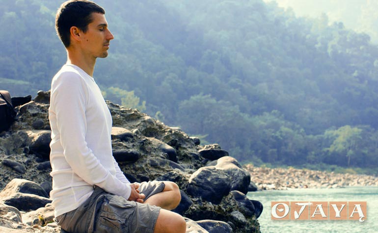 Young Man meditating by the River Ganges
